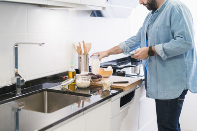 Man cooking in the kitchen in a denim shirt