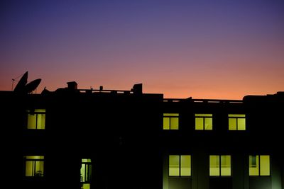 Silhouette building against clear sky during sunset