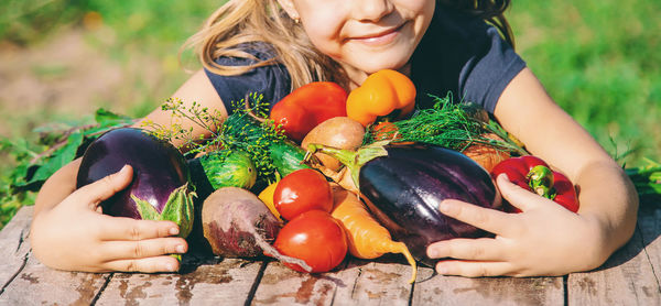 Midsection of girl with fresh vegetables