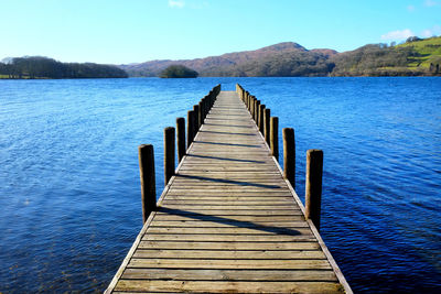 Pier over lake against clear sky