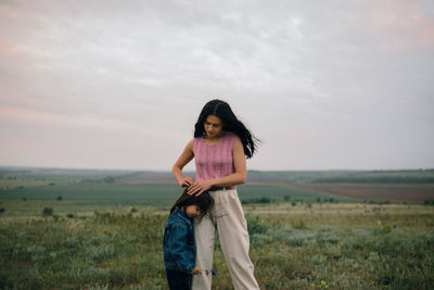 Portrait of a smiling young woman standing on field