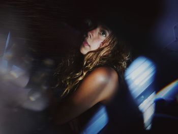 Young woman seen through glass window at home