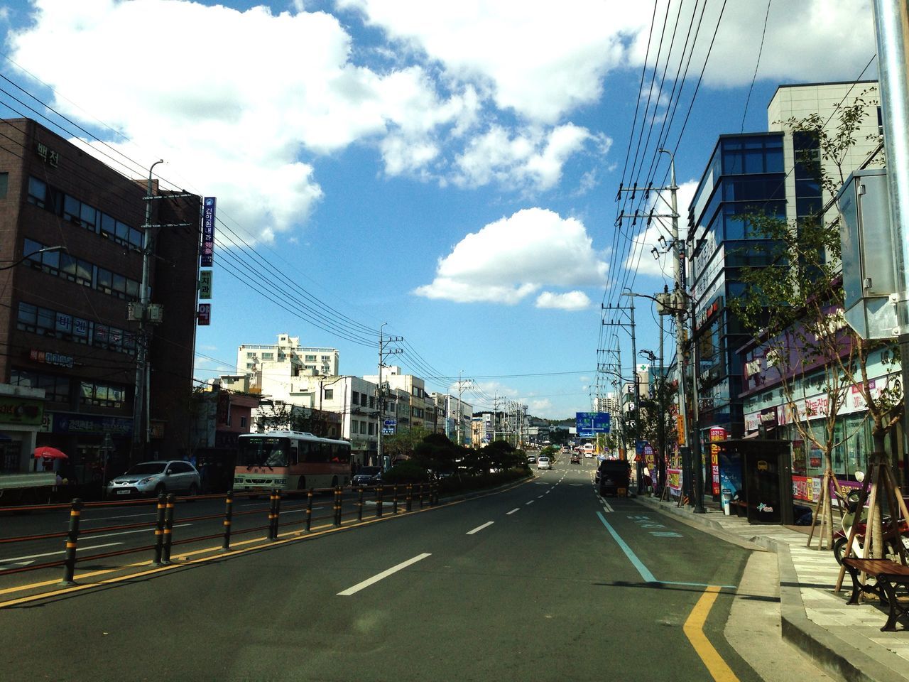 building exterior, architecture, built structure, city, the way forward, transportation, street, road, sky, diminishing perspective, car, road marking, power line, vanishing point, building, electricity pylon, city street, city life, residential structure, residential building