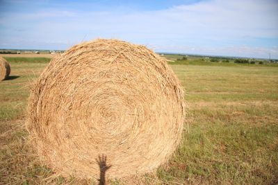 Hay bales on field against sky