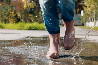 Low section of man splashing water in rain