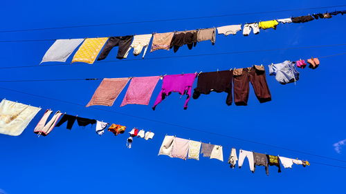 Low angle view of clothes drying against blue sky