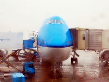 Close-up of airplane at airport against sky