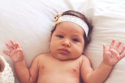 High angle view of baby lying on bed