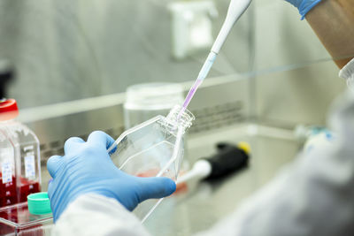 Midsection of scientist examining chemical in laboratory