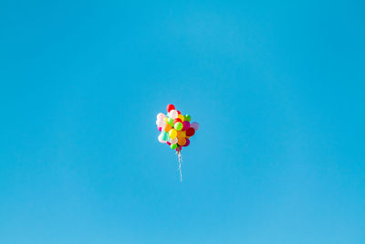 Low angle view of balloons against blue sky