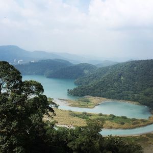 Scenic view of lake and mountains against sky