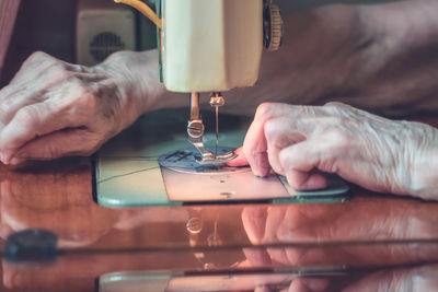 Cropped image of tailor sewing on machine