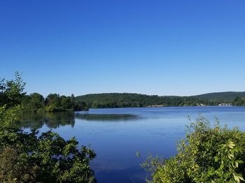 Scenic view of lake against clear blue sky