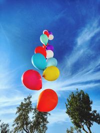 Low angle view of balloons against blue sky