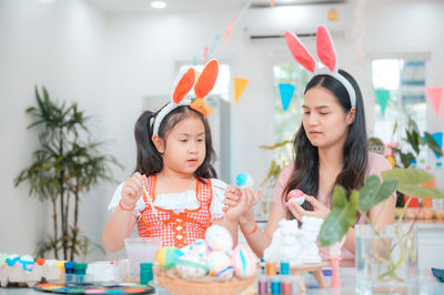 Portrait of mother and daughter on table