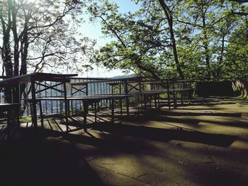 Railing by trees against sky