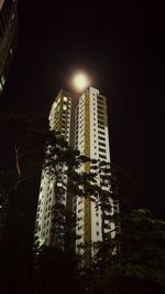 Low angle view of illuminated buildings against sky at night