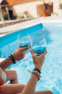 Boyfriend and girlfriend drinking wine by the pool