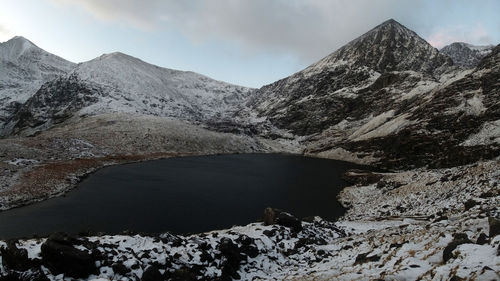 Scenic view of lake and snowcapped mountains against sky