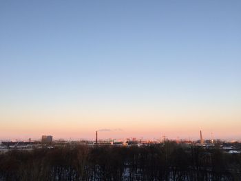 Scenic view of city against clear sky during sunset