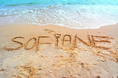 High angle view of text on sand at beach