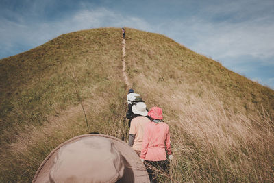 Rear view of man on field against sky