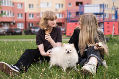 Side view of woman with dog on grassy field