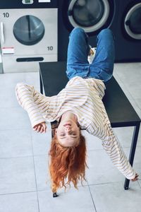 High angle portrait of happy woman sitting on tiled floor