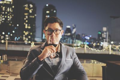 Portrait of man drinking wine while sitting at restaurant