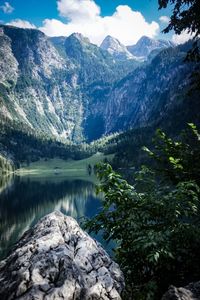 Scenic view of lake by mountains against sky