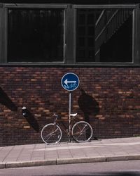 Bicycle sign on road against building