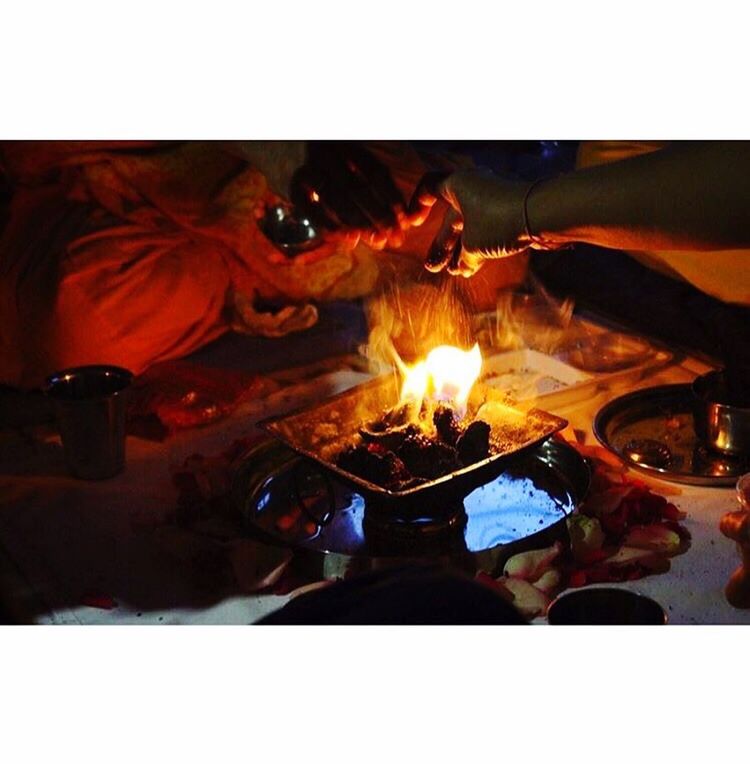 CLOSE-UP OF HANDS WITH FIRE AT NIGHT