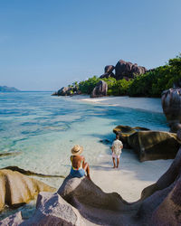 Rear view of woman relaxing at beach