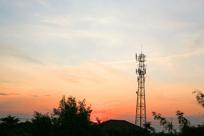 Low angle view of communications tower against sky during sunset