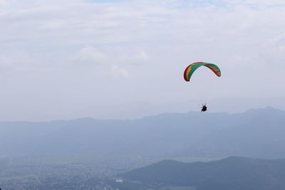 Person paragliding against sky