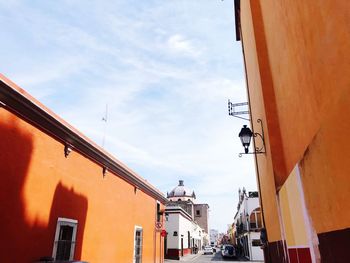 Houses by street against sky in city