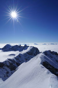 Scenic view of snowcapped mountains against blue sky