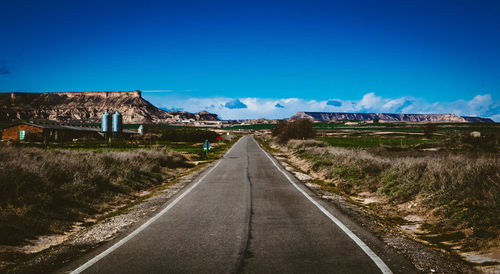 Surface level of road against clear blue sky