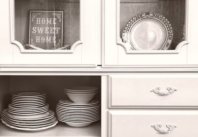 Ceramics arranged in cabinet at kitchen