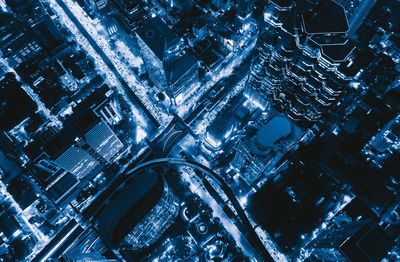 High angle view of illuminated street amidst buildings at night