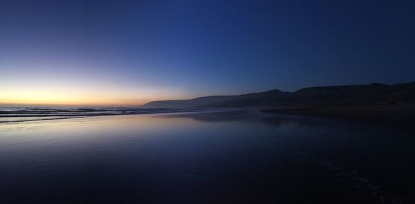 Scenic view of sea against clear sky during sunset