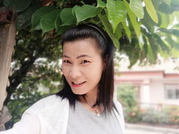 Portrait of woman standing by plants