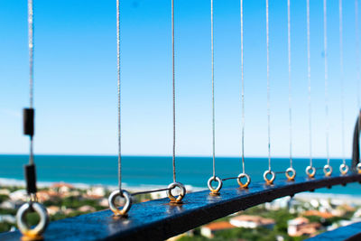 Close-up of rope hanging on railing against sea