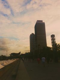 People in city against sky during sunset