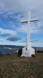 Cross by sea against sky