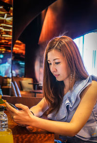 Beautiful woman using mobile phone at cafe