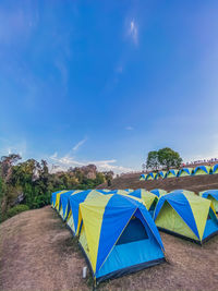 Multi colored tent on hillside against sky