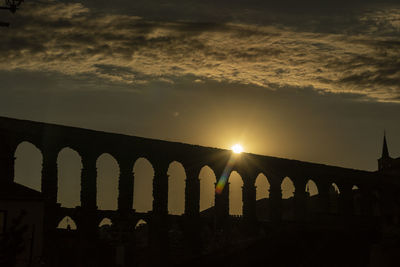 Low angle view of bridge against sky at sunset