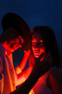 Close-up of couple at night looking at camera