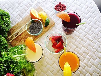 High angle view of fruits and drinks served on table